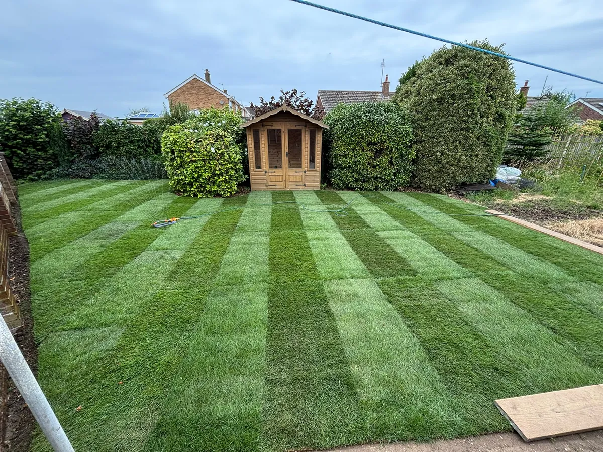 A freshly laid striped lawn beside a summer house in a large Norfolk garden