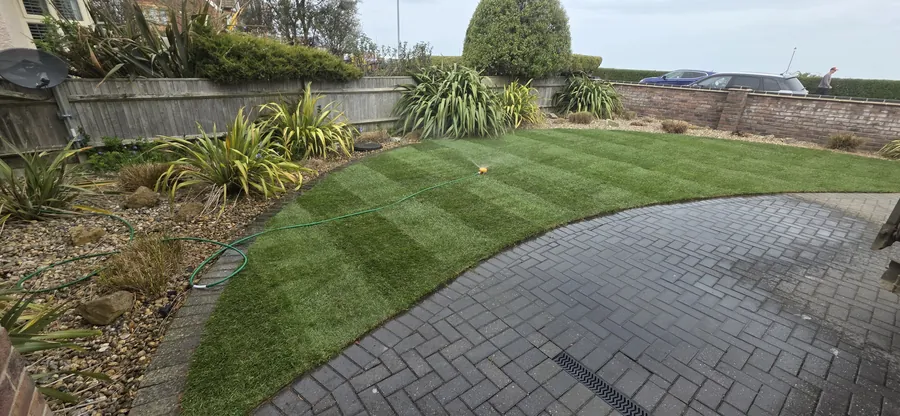Striped replacement lawn beside block paving in Norfolk
