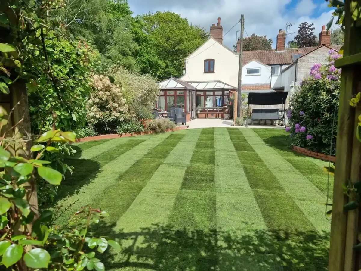 A flat, even striped lawn leading up to a house in Norfolk